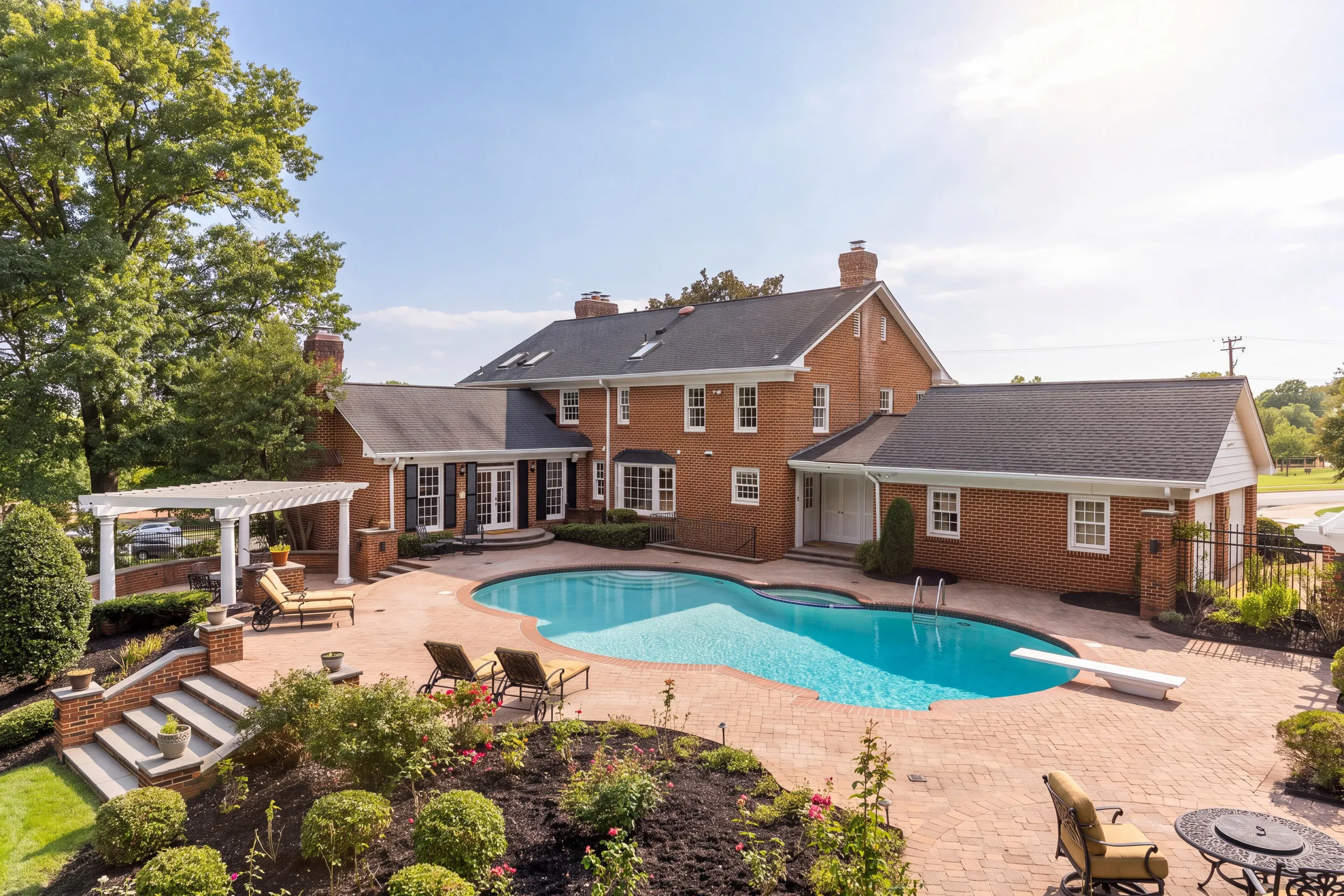 After: the same home with an AI Studio sky replacement, a clear blue sky and warm sunlight across the brick and pool
