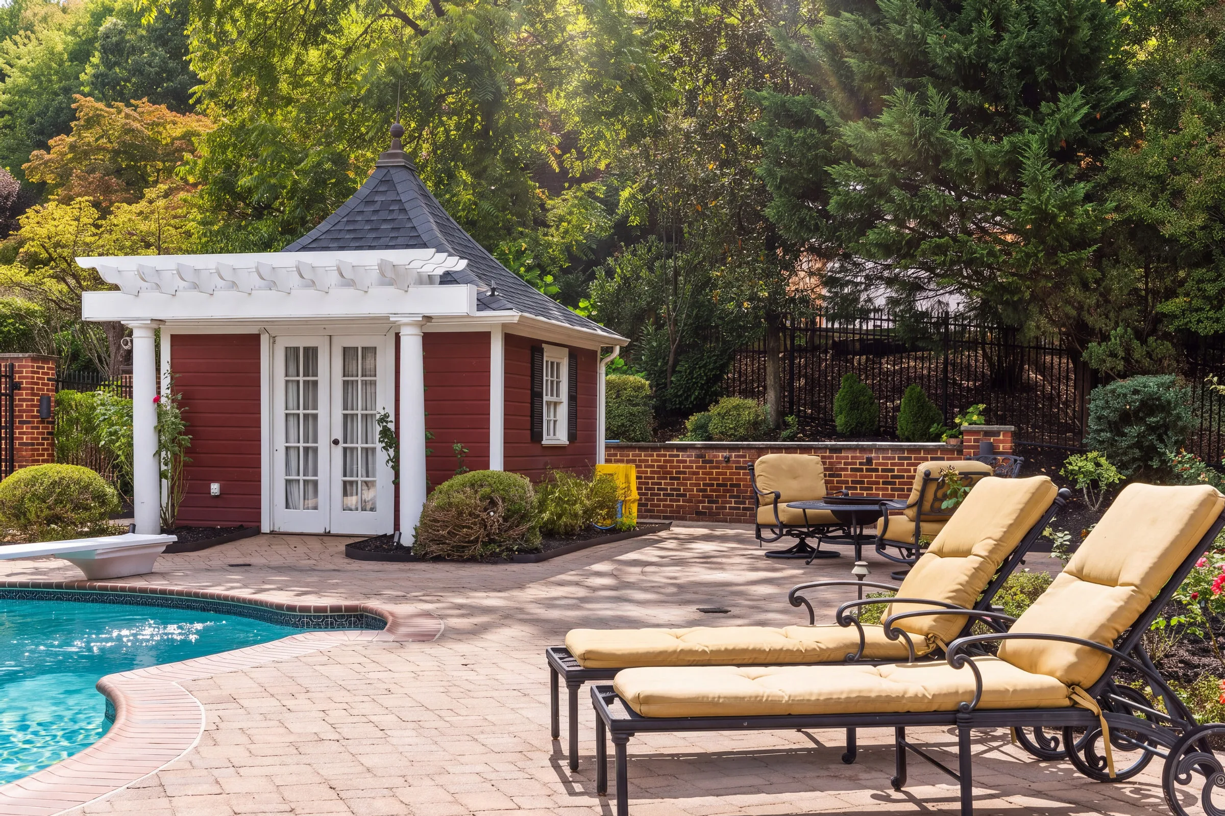 After: the same pool house in AI Studio with dappled sunlight through the trees across the patio and loungers